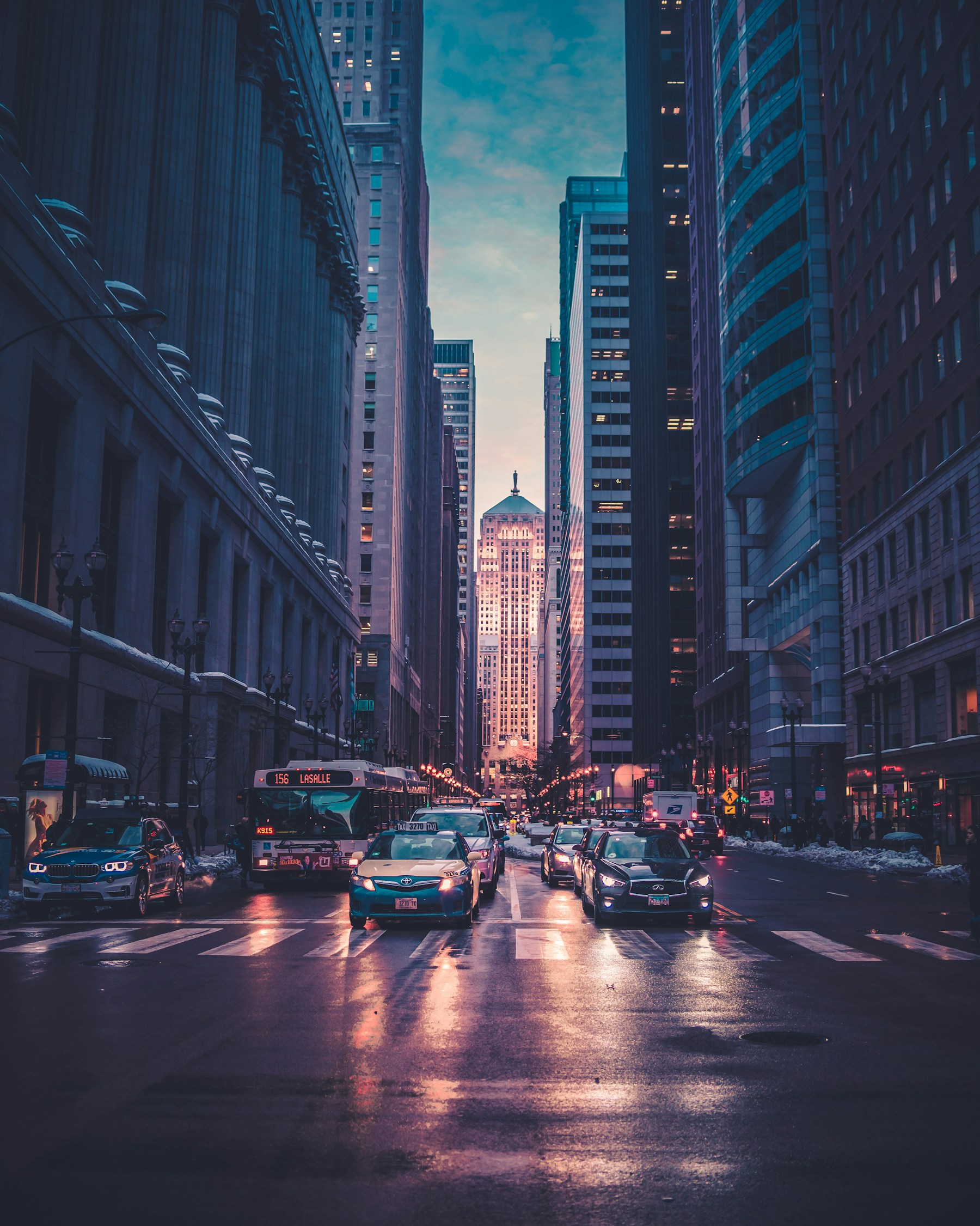 Downtown financial district buildings overlooking a busy city street at dusk
